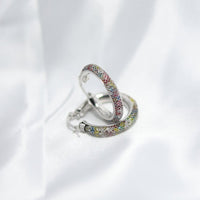 Silver earring with colorful stones on a white background