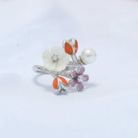 Silver ring with floral designs on a white surface 
