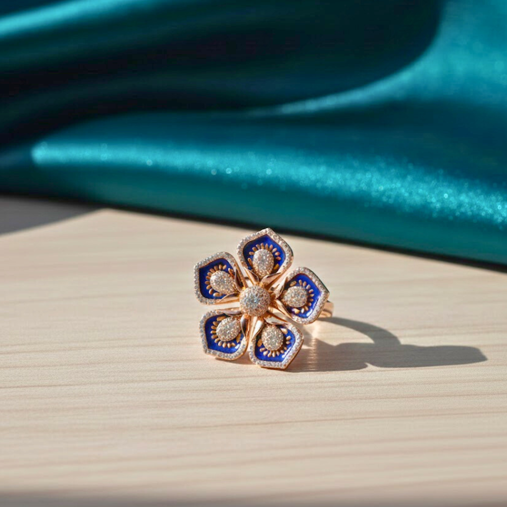 Floral ring with blue and gold accents on a wooden surface with teal fabric in the background