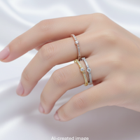 Hand wearing two diamond rings on a white background